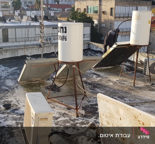 אדם עובד על איטום גג עם חומרי איטום
